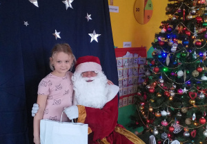 dziewczynka pozuje do zdjęcia z Mikołajem